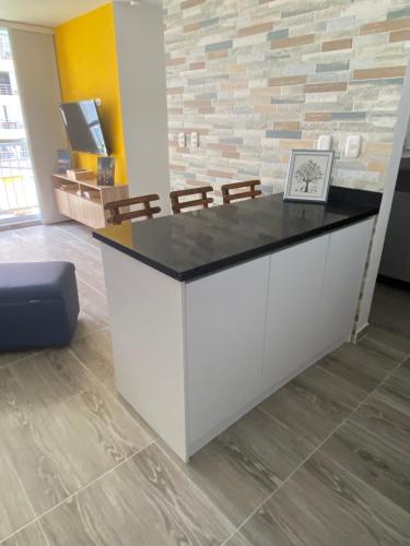 a reception desk in an office with a stone wall at Acogedor apartamento in Armenia