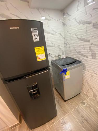 a machine with a trash can next to a wall at Acogedor apartamento in Armenia