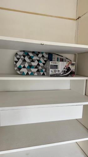 a white shelf in a closet with some items on it at Studio cosy aux portes de Geneve in Ferney-Voltaire
