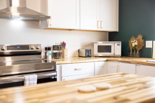 a kitchen with white cabinets and stainless steel appliances at Downtown Garden Escape in Casper