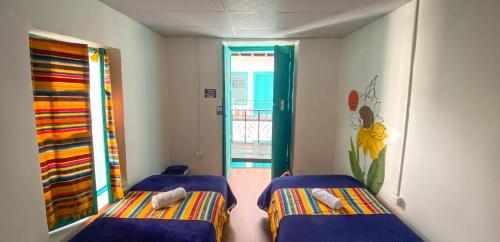 a small room with two beds and a window at Casa CarpeDM in Quito
