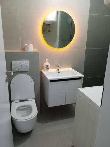 a bathroom with a toilet and a sink and a mirror at Pristhine Stay Inn 21 in Prishtinë