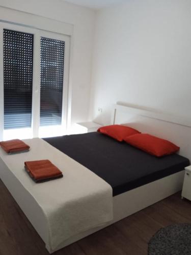 a bedroom with a large bed with red pillows on it at Pristhine Stay Inn 21 in Prishtinë
