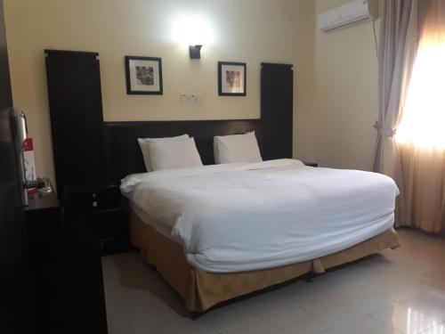 a bedroom with a large bed with white sheets at Zekeri Maria Hotel Ventures in Lagos
