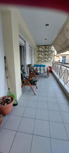 a room with a balcony with chairs and tables at Comfortable and Elegant apartment FoFi in Thessaloniki