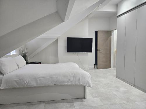 ein Schlafzimmer mit einem Bett und einem Flachbildfernseher in der Unterkunft Luxury 3 bed next to city centre in Killingbeck
