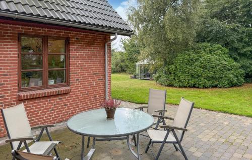 una mesa de cristal y sillas en un patio en Awesome Home In Sønder Felding With House A Panoramic View, en Sønder Felding