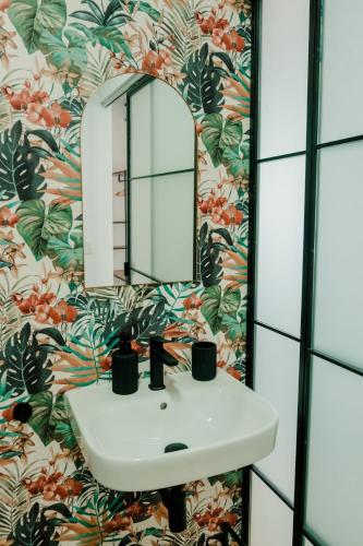 a bathroom with a sink and a floral wallpaper at Romantic Boutique Apartment 2 in Villajoyosa