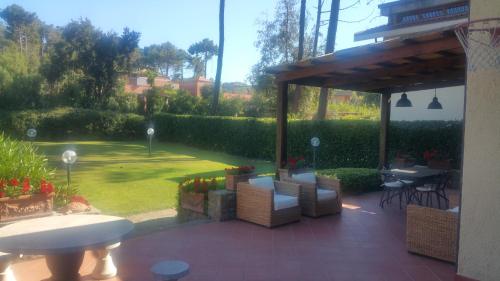 a patio with chairs and a table and a pavilion at Villetta Punta Ala in Punta Ala