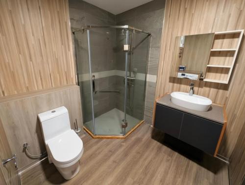 a bathroom with a shower and a toilet and a sink at ICHA Apartments in Suva