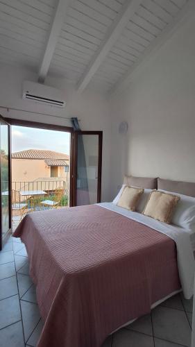 a bedroom with a large bed with a balcony at Le Rose Antiche in Murta Maria