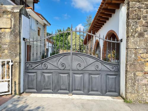 ein graues Garagentor mit einem Metalltor in der Unterkunft Gran casa rural con Finca de 4000 m2 in Quijano