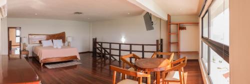a bedroom with a bed and a table and chairs at Cuxos Hotel Beachfront in Isla Mujeres
