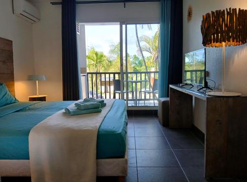 een slaapkamer met een bed en uitzicht op een balkon bij Studio Marina Blue in Saint-François