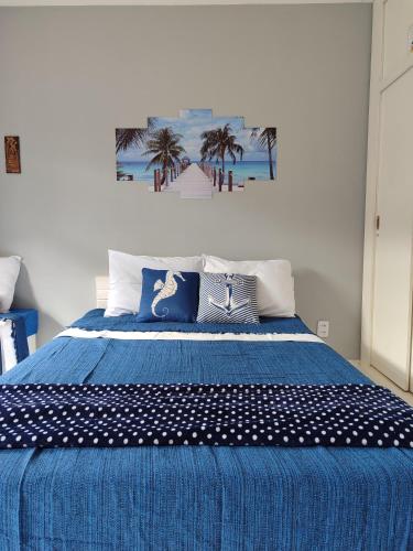 a bedroom with a blue bed with palm trees on it at Refúgio Peró - Praia, piscina e churrasqueira in Cabo Frio