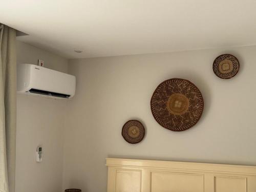 a kitchen with three plates on the wall and a microwave at Peter's Nest in Livingstone