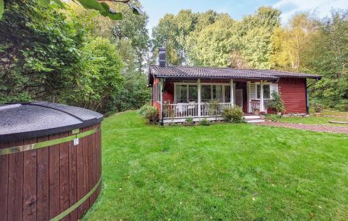 a small red house with a fence in the yard at 2 Bedroom Amazing Home In Örkelljunga in Åsljunga