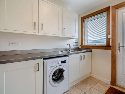 a kitchen with a washing machine and a sink at 2 Bed in Killin PE512 in Killin
