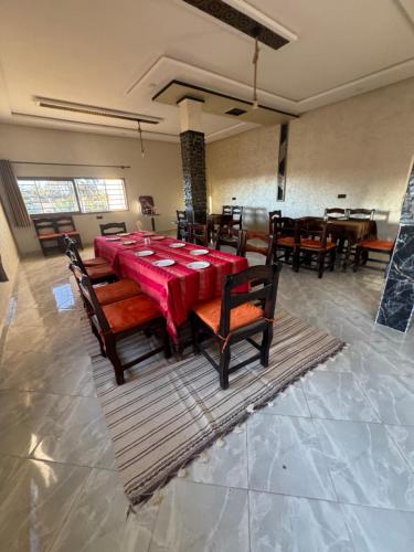 a dining room with a red table and chairs at Riad Restaurant Mifis in Rissani