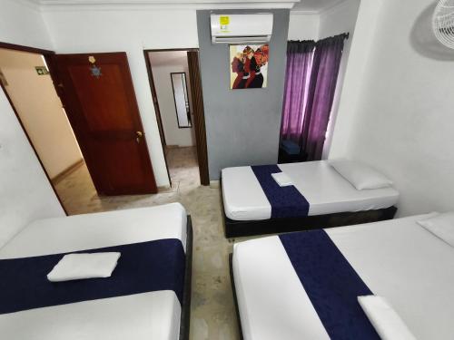 a small room with two beds and a mirror at Cabaña Gaia Rodadero in Santa Marta
