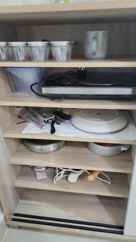 a refrigerator drawer filled with dishes and a microwave at Waterfront apartment with a breathtaking view in Sharjah