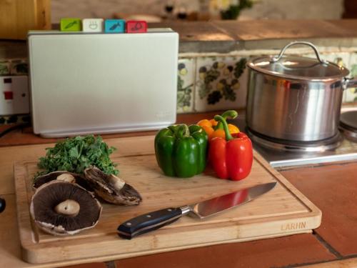 a cutting board with vegetables and a knife on a counter at 5 Bed in Selkirk TOWER in Selkirk