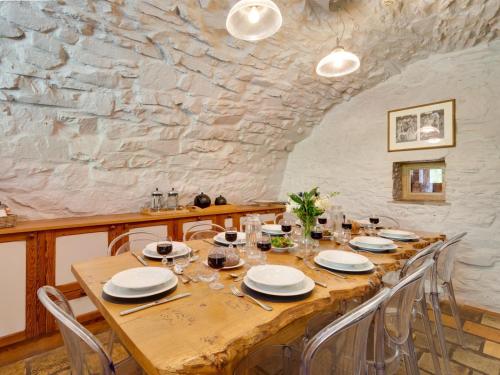 a long wooden table with chairs and a stone wall at 5 Bed in Selkirk TOWER in Selkirk
