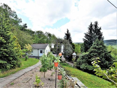 a garden with trees and a white house at 1 Bed in Aberdare 82906 in Merthyr Tydfil