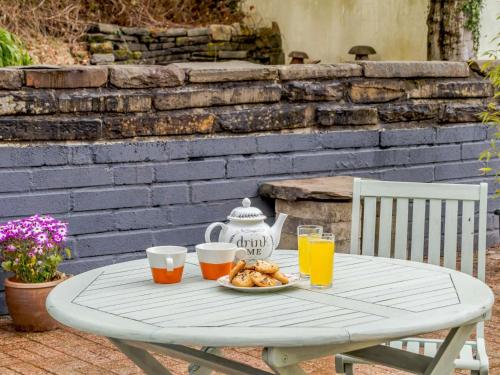 a white table with a plate of food and orange juice at 1 Bed in Aberdare 82906 in Merthyr Tydfil