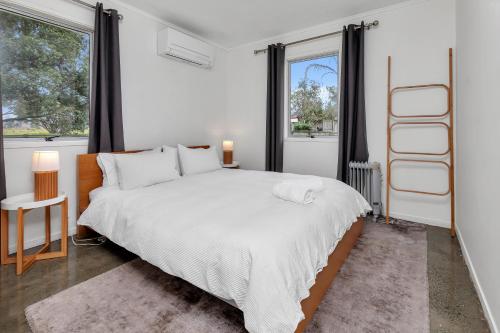 a bedroom with a large bed and a window at Ruakaka Coastal Reserve Retreat in Ruakaka