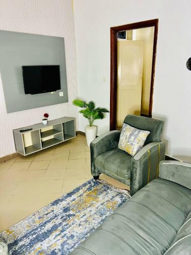 a living room with a couch and a television at Orange Room in Dakar