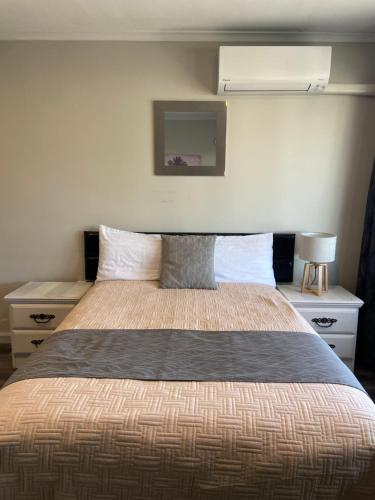 a bedroom with a large bed with two night stands at A1 Kaikoura Motel & Apartment in Kaikoura