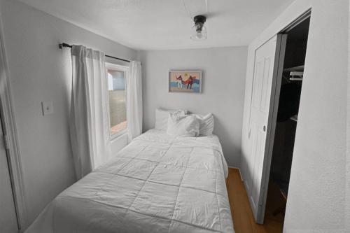 a small bedroom with a bed and a window at Sea Haven Motel Unit .5 in Rockaway Beach