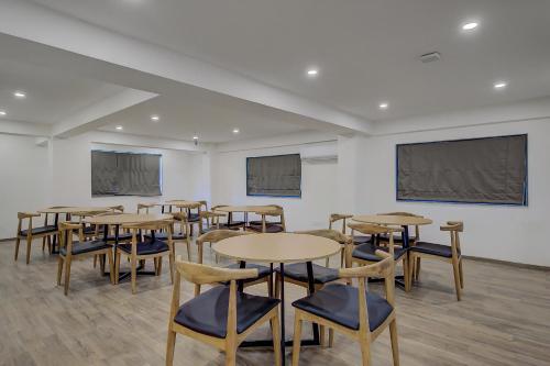 a classroom with tables and chairs and a projection screen at Super Townhouse Hadapsar in Pune