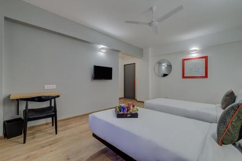 a hotel room with a bed and a desk at Super Townhouse Hadapsar in Pune
