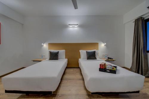 two beds in a hotel room with at Super Townhouse Hadapsar in Pune