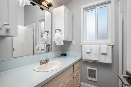 a bathroom with a sink and a mirror at Beachfront Family Sanctuary in Rockaway Beach
