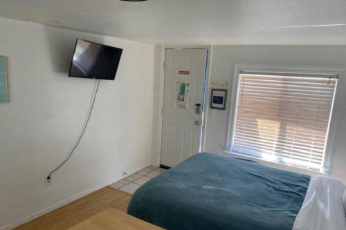 a bedroom with a bed and a television on the wall at Sea Haven Motel Unit #4 in Rockaway Beach