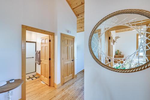 a hallway with a round mirror and a hallway with a door at Walk to Dtwn Syracuse Private Lake-View Home in Syracuse