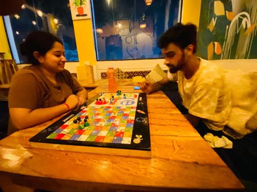 a man and a woman playing a board game on a table at The Commune Banaras in Varanasi