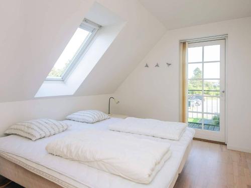a white bed in a room with a window at 5 star holiday home in Rømø in Sønderby