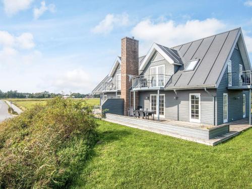 a blue house with a porch and a deck at Panoramic Golf View Retreat - By Traum Ferienwohnungen in Sønderby