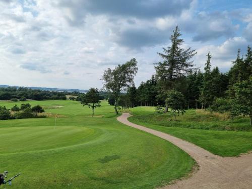 a dirt road leading to a golf green at 7 person holiday home in Skals-By Traum in Skals
