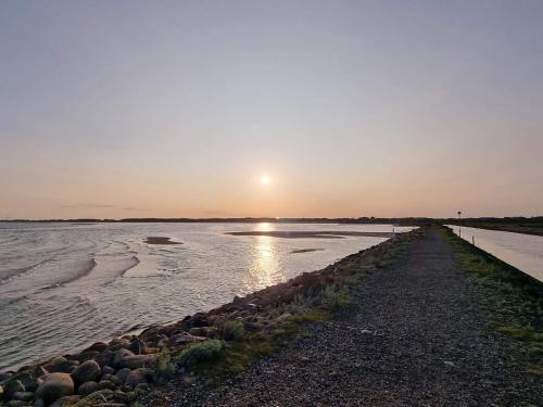 a sunset over a body of water with a pier at 6 person holiday home in Asaa-By Traum in Aså