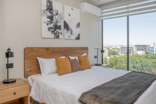 a bedroom with a large bed with a large window at Modern Stay in the Heart of Guadalajara in Guadalajara