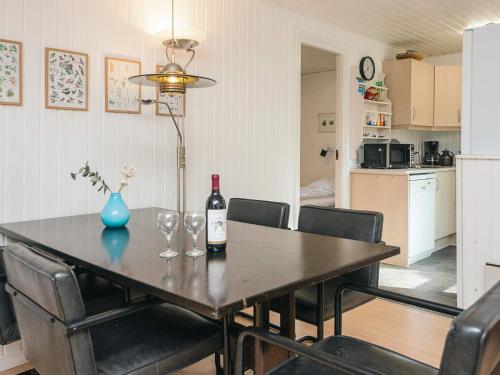 a dining room table with a bottle of wine and chairs at Tranquil Retreat in Romo - By Traum Ferienwohnungen in Toftum