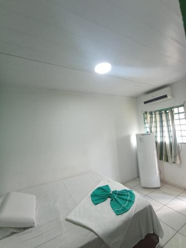 a bedroom with a bed with a green bow on it at Pousada casa verde in Bonito