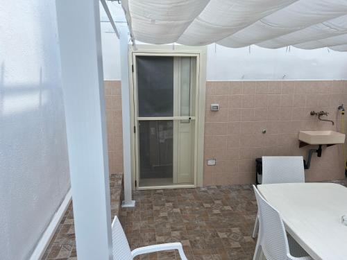 a room with a table and chairs and a window at Notos b&b in Otranto