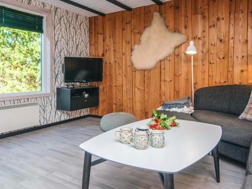 a living room with a table and a couch at 6 person holiday home in Rømø-By Traum in Bolilmark
