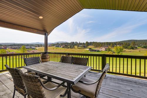 a wooden table and chairs on a deck at 4 Mi to Dtwn Sturgis Cabin with Hot Tub and Game Room in Crook City